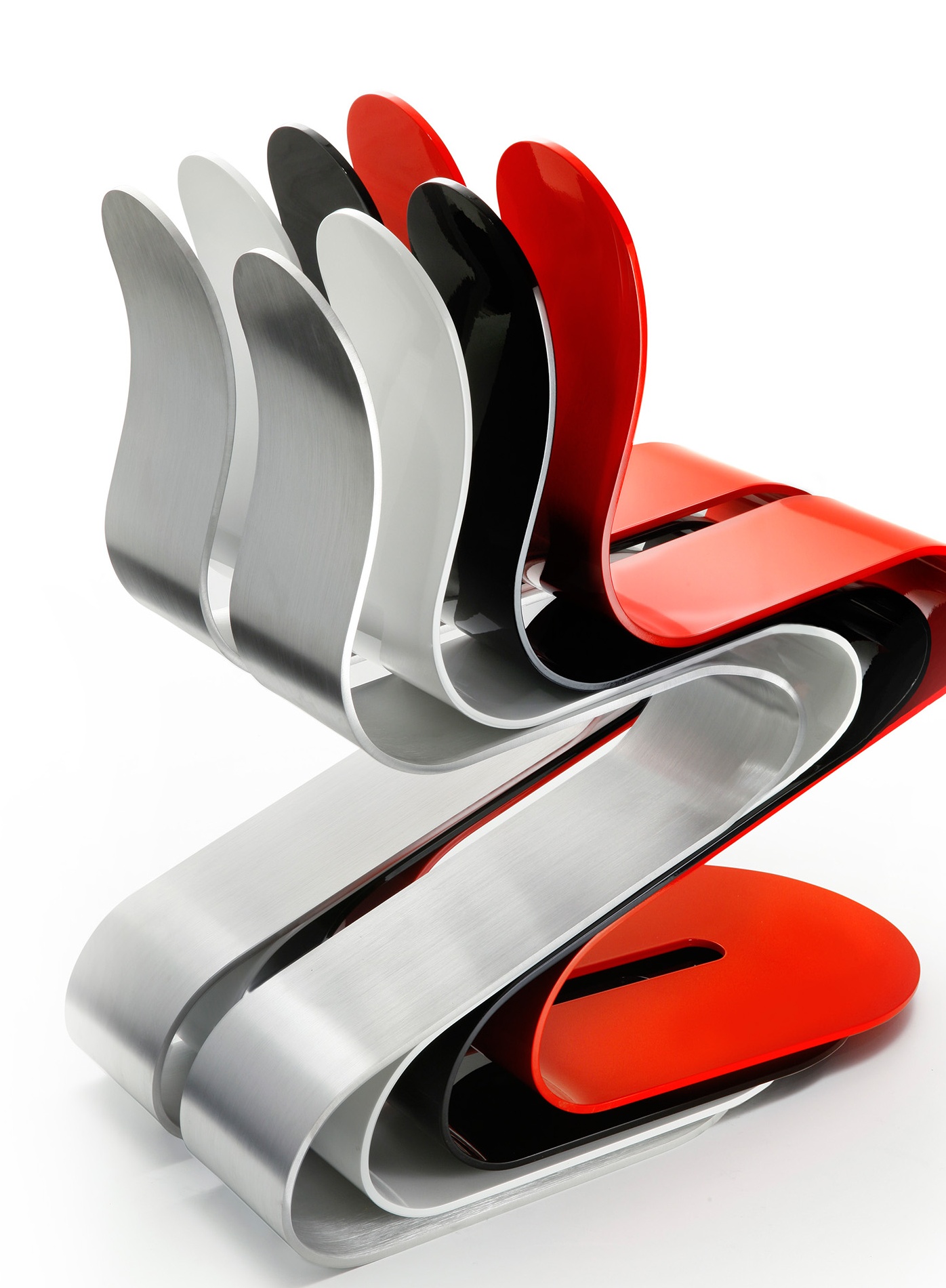 Four aluminum Fluid Ribbon Chairs stacked and nested into one another